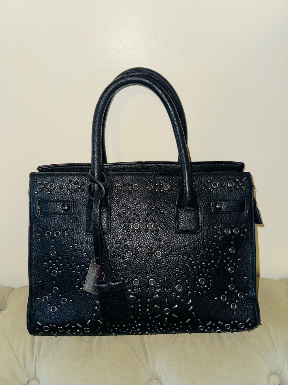Women’s black handle bag with metal design in the front
